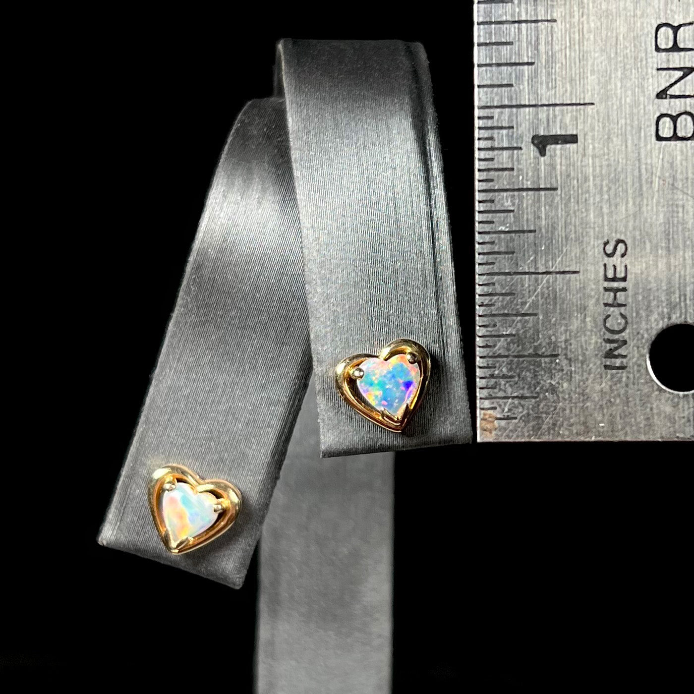 A pair of yellow gold stud earrings mounted with heart shaped natural crystal opals.