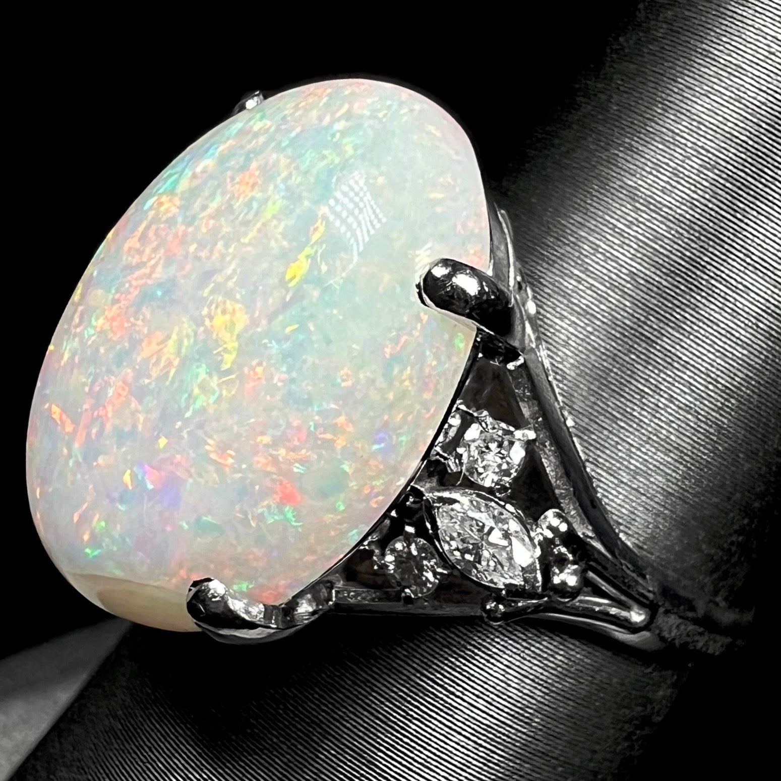 A platinum statement ring mounted with a 7.97ct Coober Pedy opal and marquise cut diamond accents.