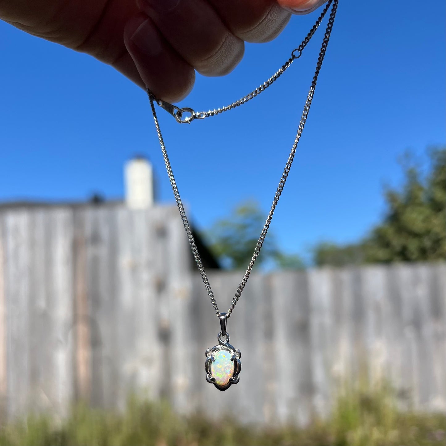 A platinum opal necklace on a platinum chain.  The opal weighs 1.49ct and has predominantly green color play.