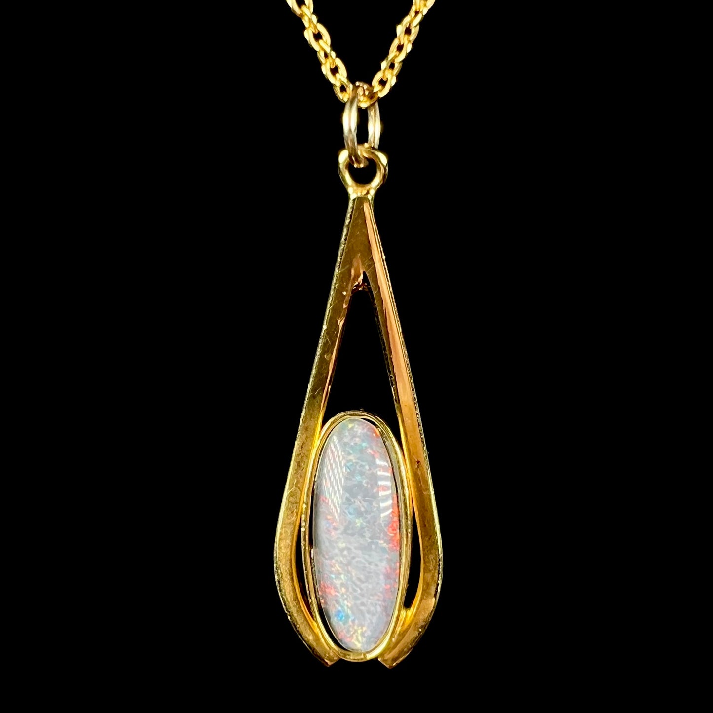 A yellow gold plated necklace set with an oval cut opal triplet.