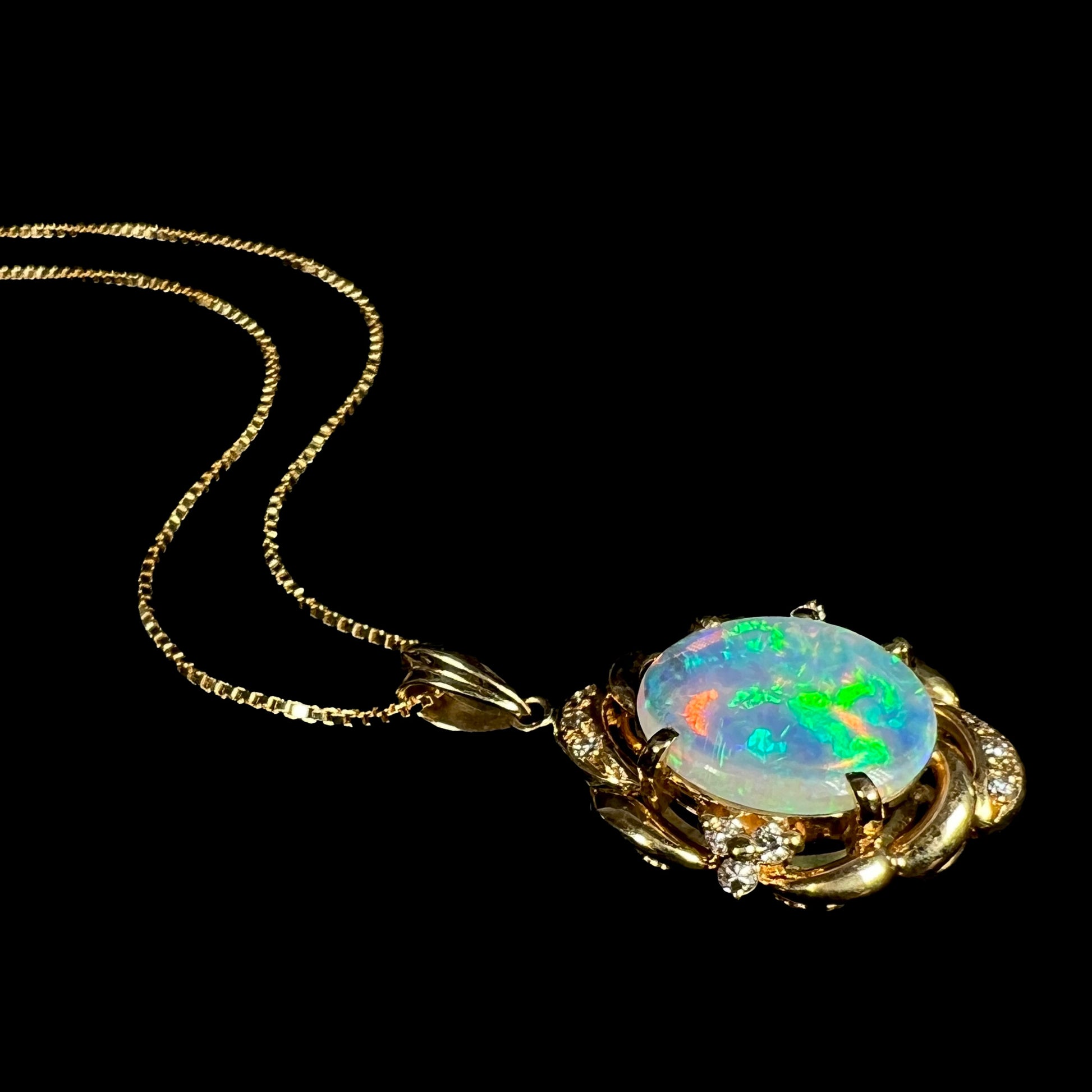 An 18 karat yellow gold diamond-accented necklace mounted with a green and blue Lightning Ridge crystal opal.