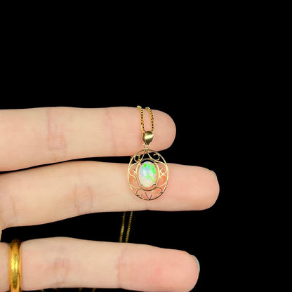 An 18 karat yellow gold filigree opal necklace.  The opal has bright green color play.