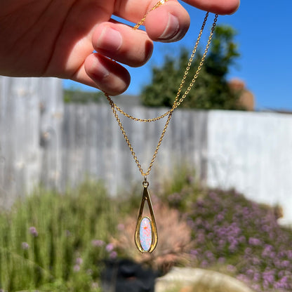 A yellow gold plated necklace set with an oval cut opal triplet.