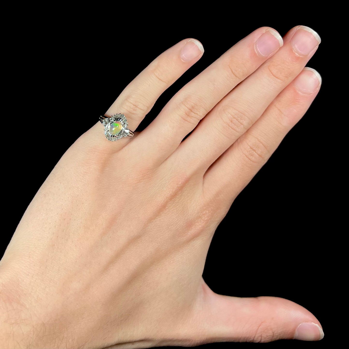 A platinum ring mounted with a Mexican fire opal and baguette cut diamond accents.