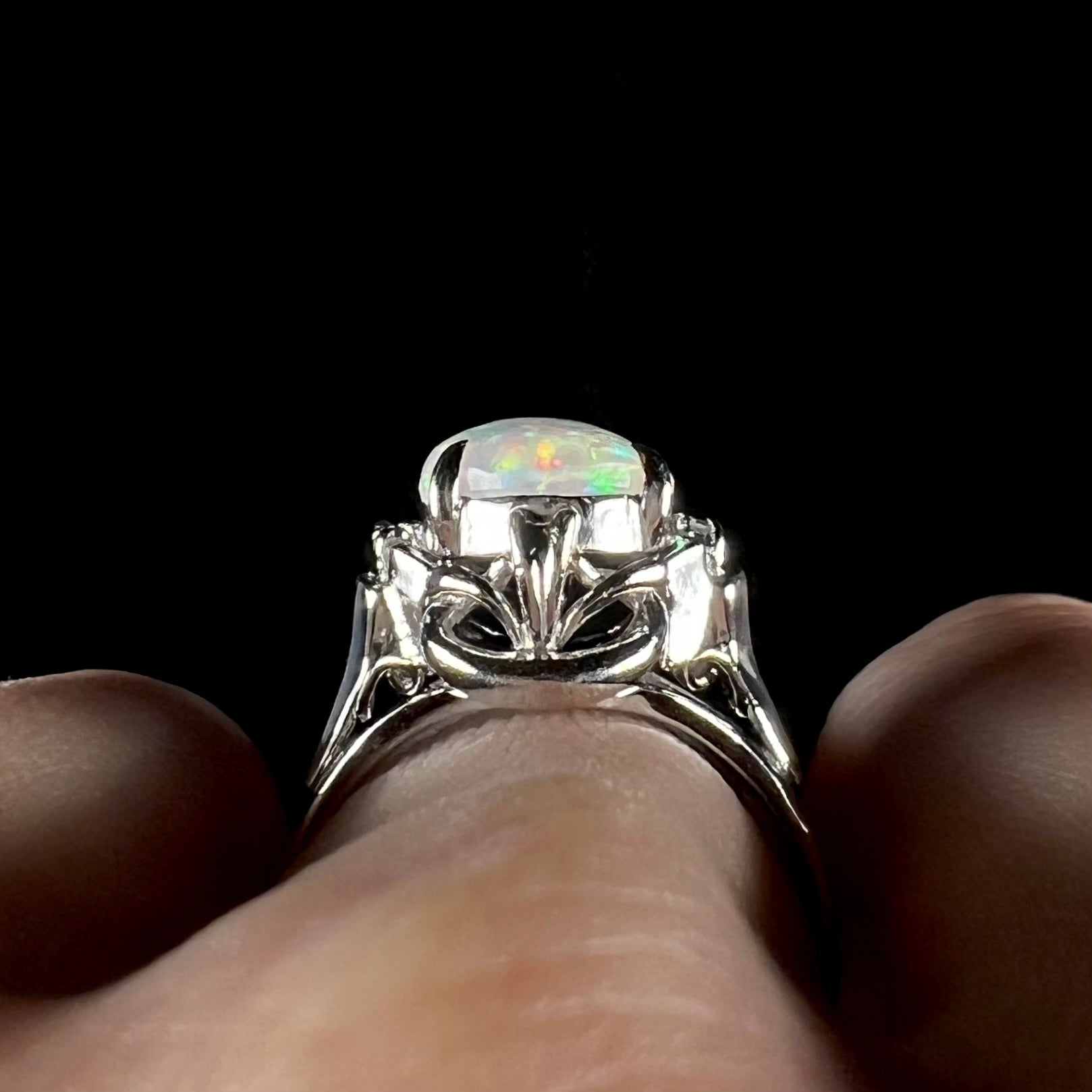 A platinum  and diamond ring prong-set with an Australian opal.  The opal has pink color play.