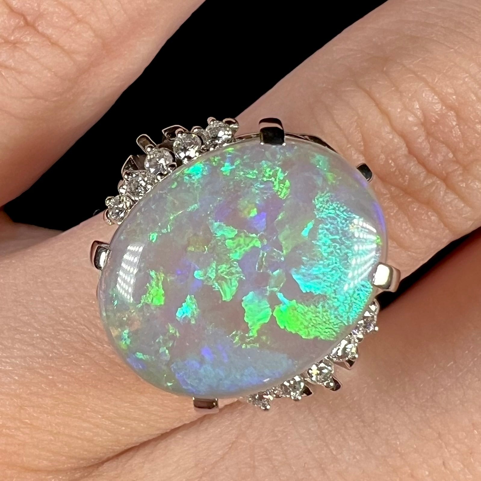 A platinum filigree ring set with a large, green-blue Mintabie crystal opal and diamonds.