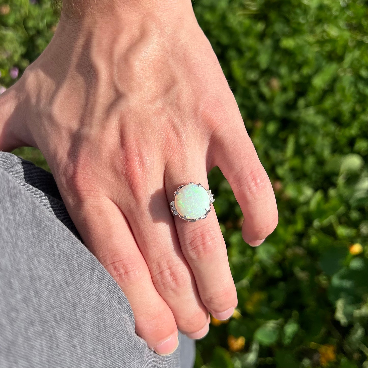 A round cut Australian opal and diamond engagment ring with platinum filigree.