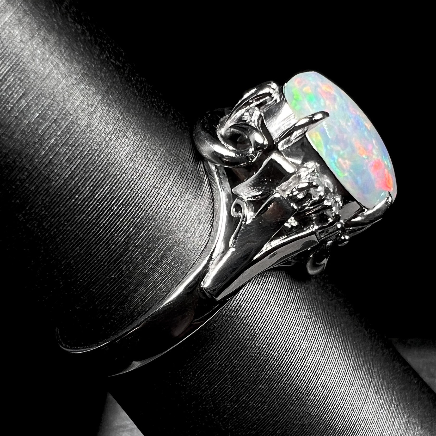 A platinum  and diamond ring prong-set with an Australian opal.  The opal has pink color play.