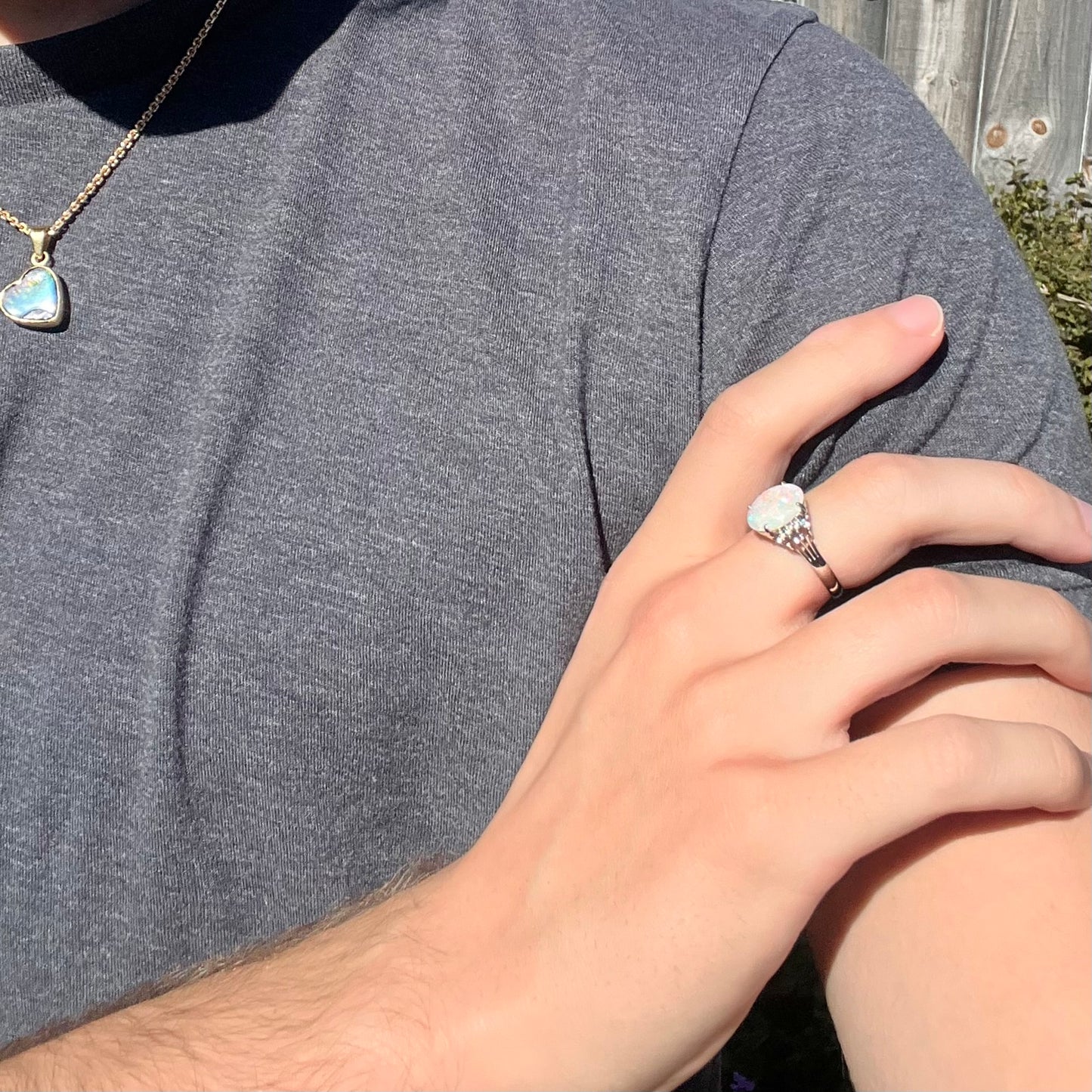 An Australian opal and diamond engagement ring in platinum.  The ring has filigree scrolling.