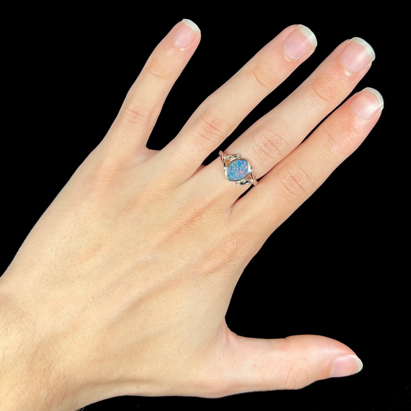 A silver leaf-style ring mounted with a multicolor black opal doublet.