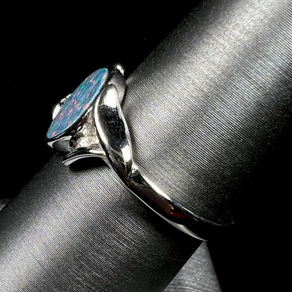 A silver leaf-style ring mounted with a multicolor black opal doublet.