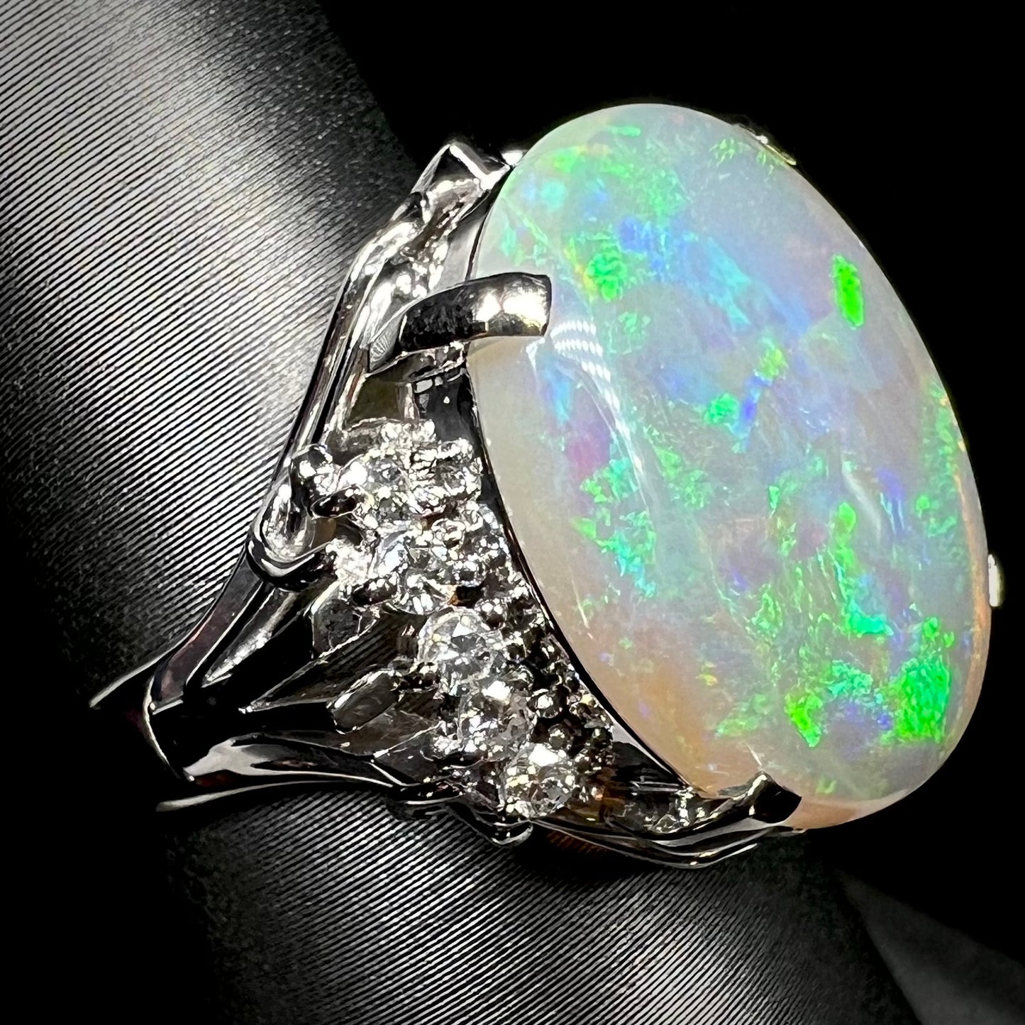 A platinum filigree ring set with a large, green-blue Mintabie crystal opal and diamonds.