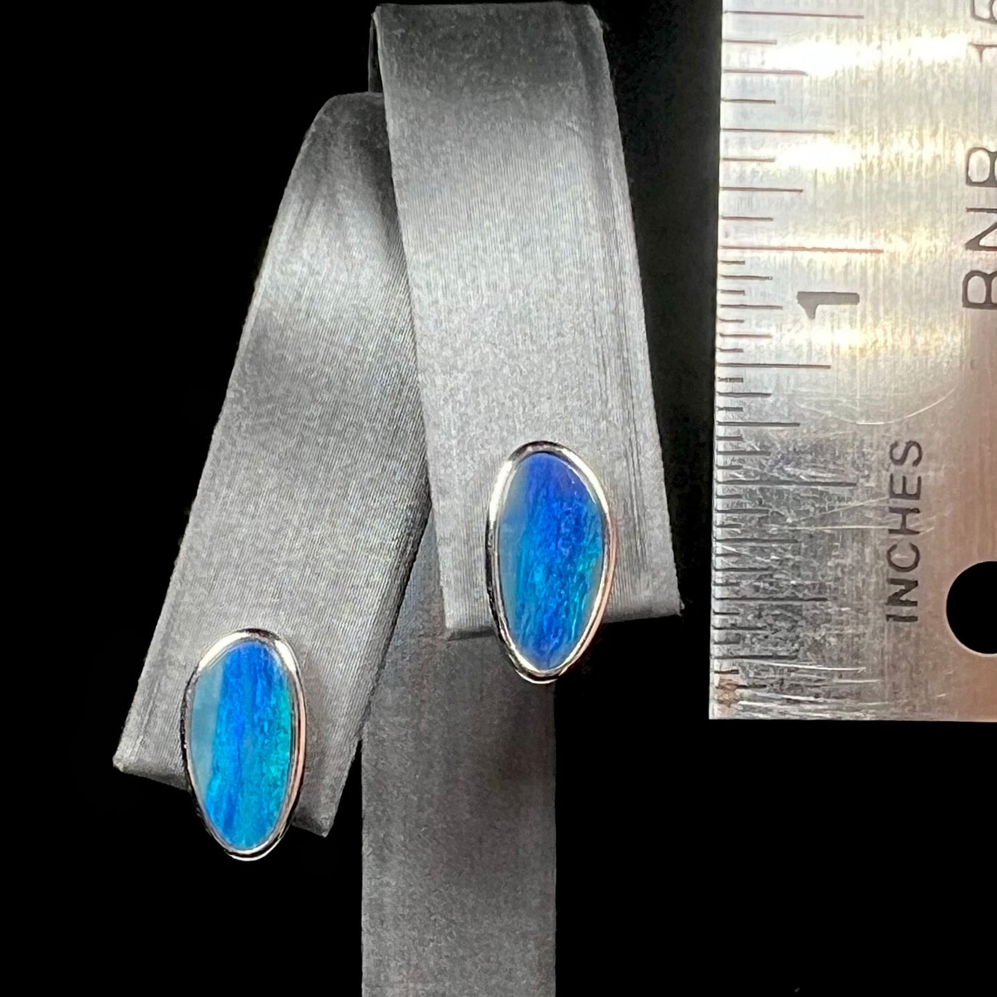 A pair of sterling silver opal doublet stud earrings.  The opals have a vivid blue color.