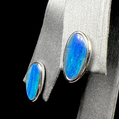 A pair of sterling silver opal doublet stud earrings.  The opals have a vivid blue color.