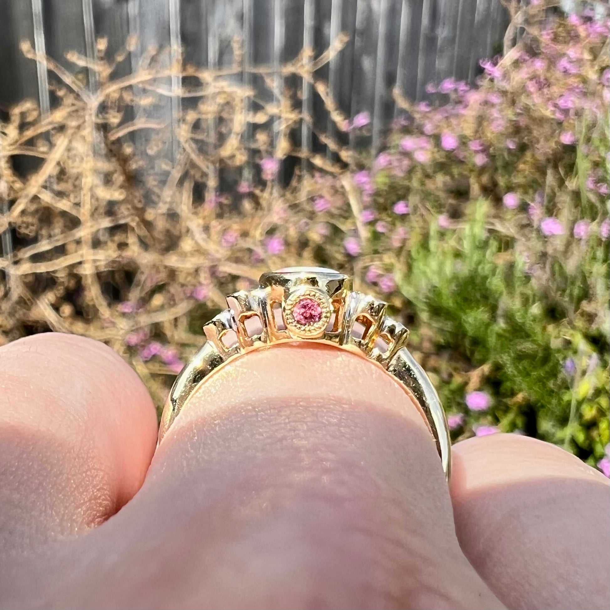 A ladies' yellow gold opal ring.  Three diamonds are set on each side of the opal.  Two rubies are set under the opal.