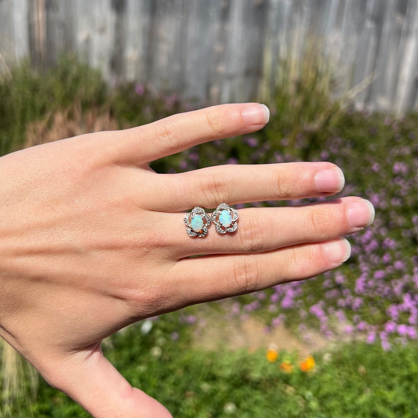 A pair of 14k white gold flower earrings mounted with opals and diamonds.