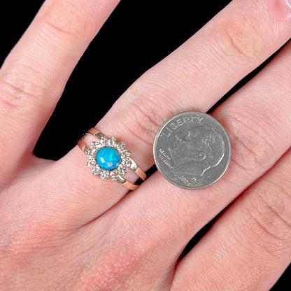 A ladies' round cut black opal and diamond halo ring.  The ring is yellow gold and has a split shank.