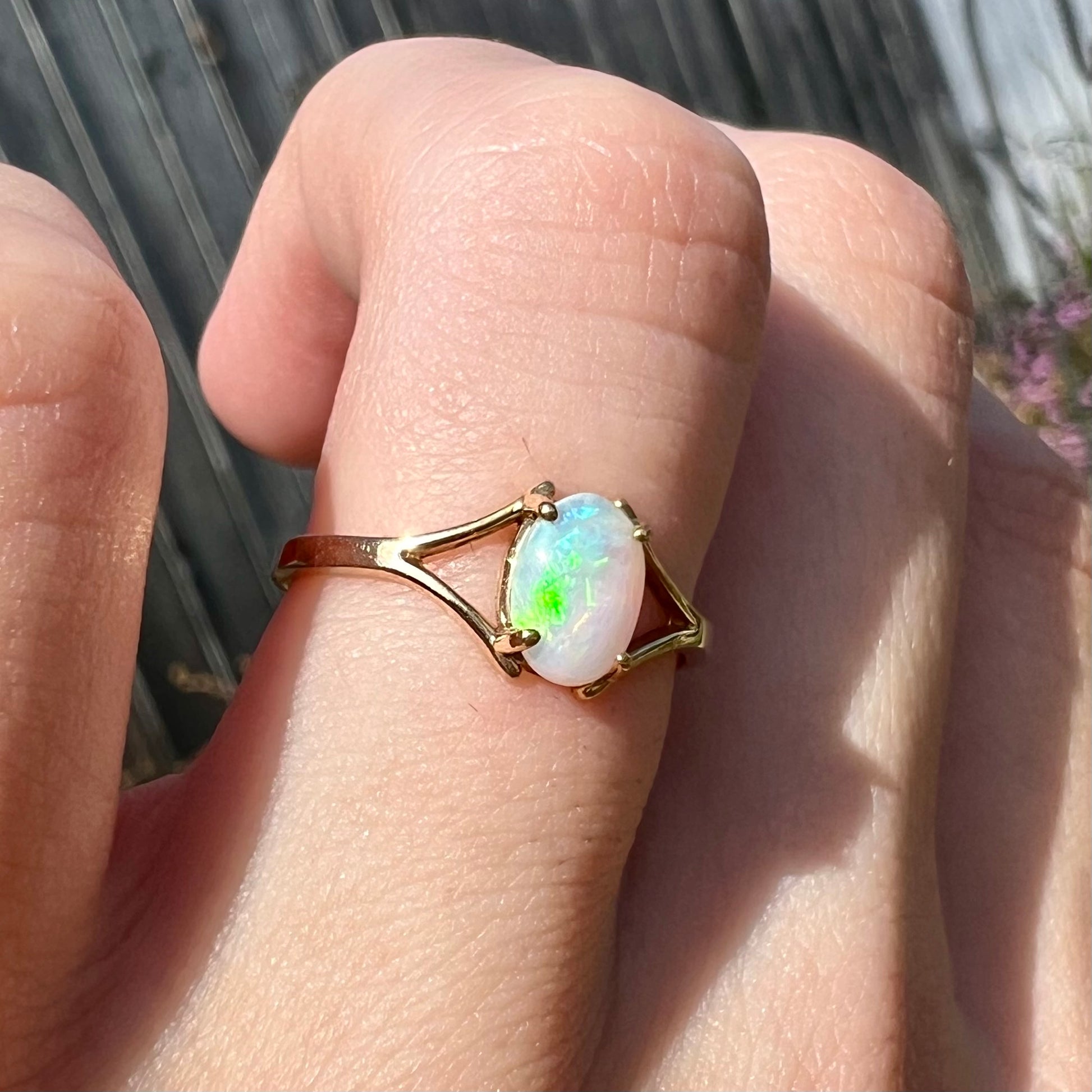 A ladies' simple opal solitaire ring.  The ring is yellow gold with a split shank.