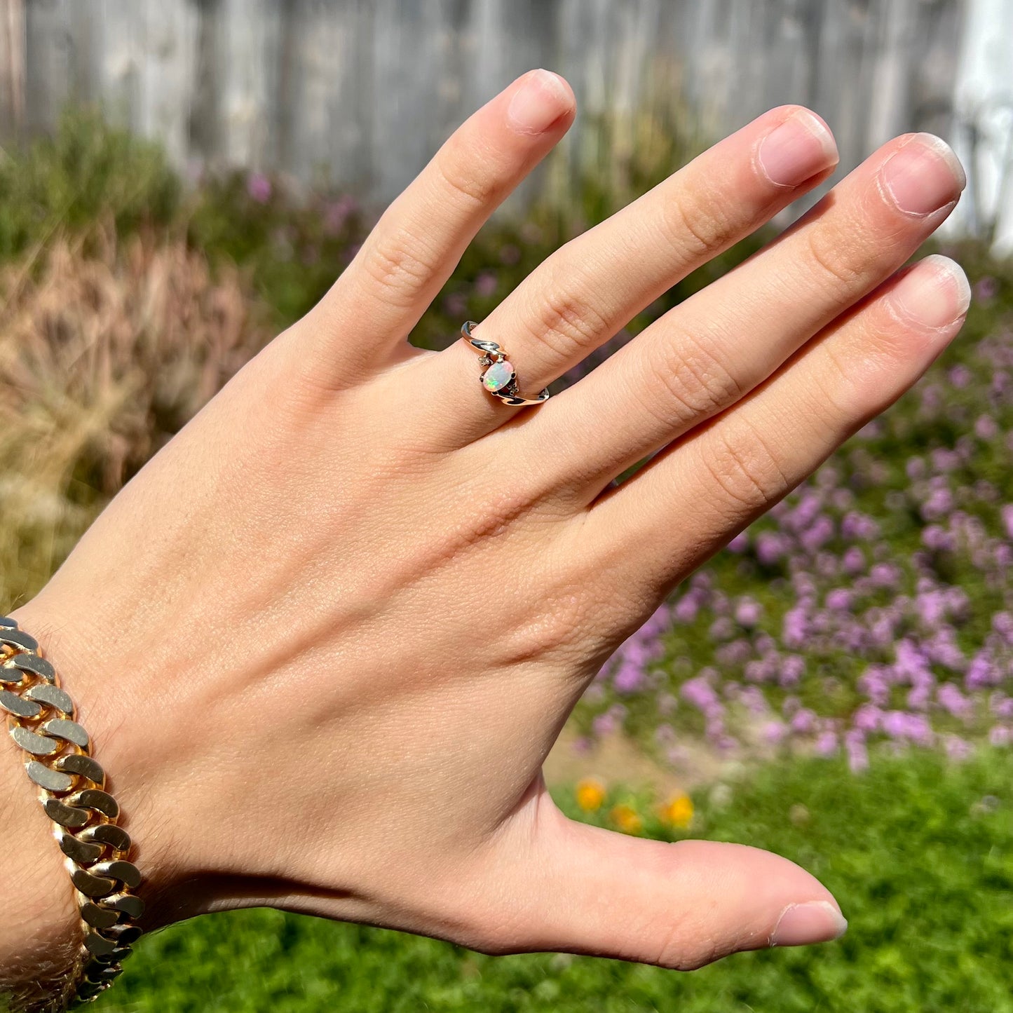 An oval cabochon cut opal and diamond engagement ring in yellow gold.