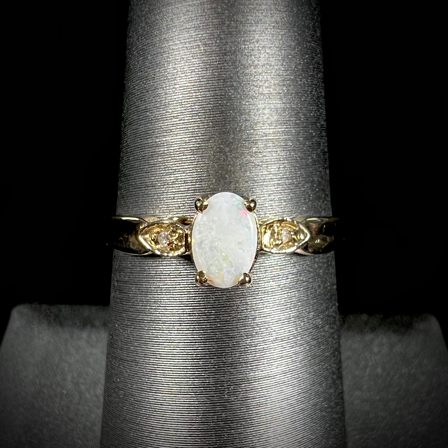 A dainty ladies' yellow gold opal and diamond ring.  The opal has subtle play of color.