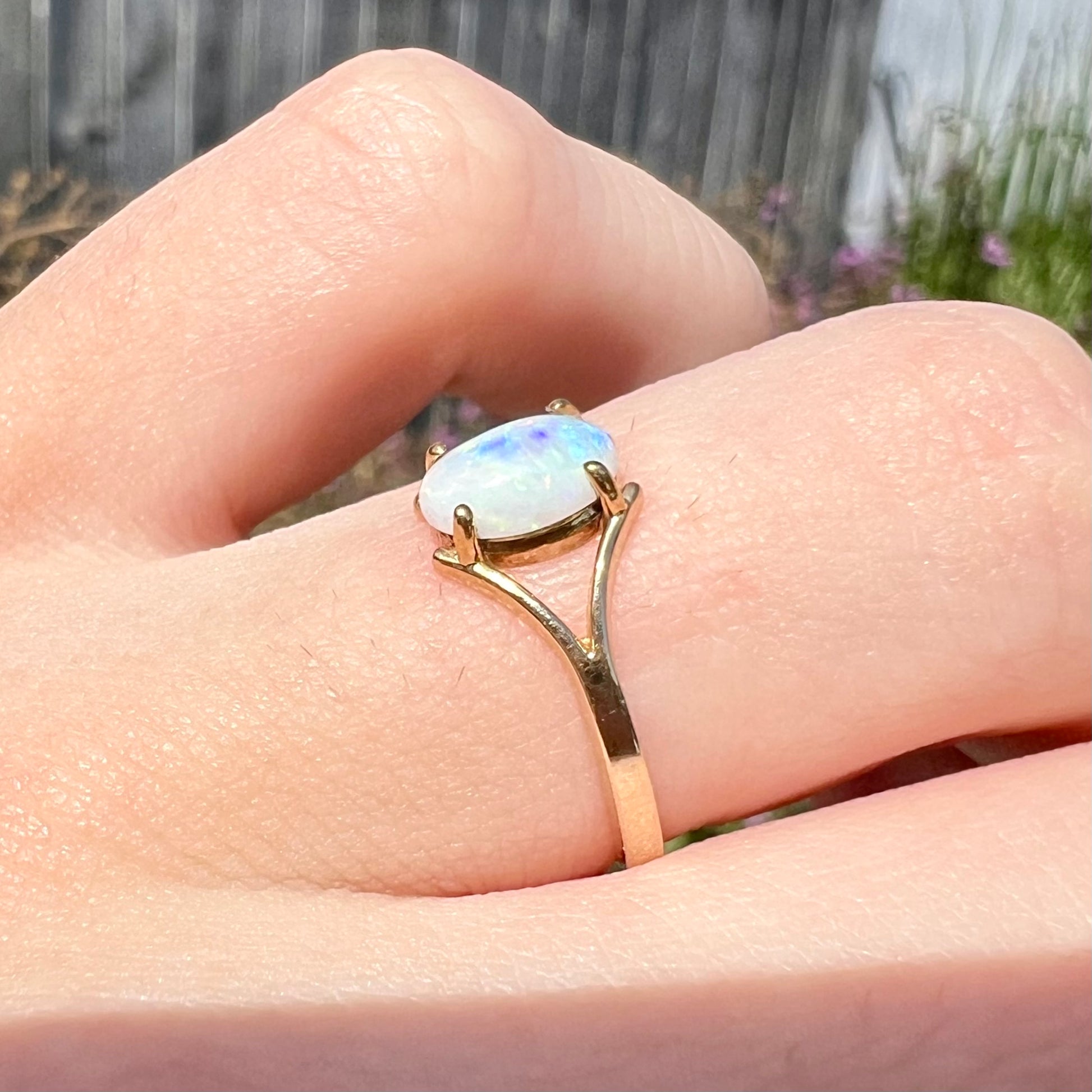 A ladies' simple opal solitaire ring.  The ring is yellow gold with a split shank.