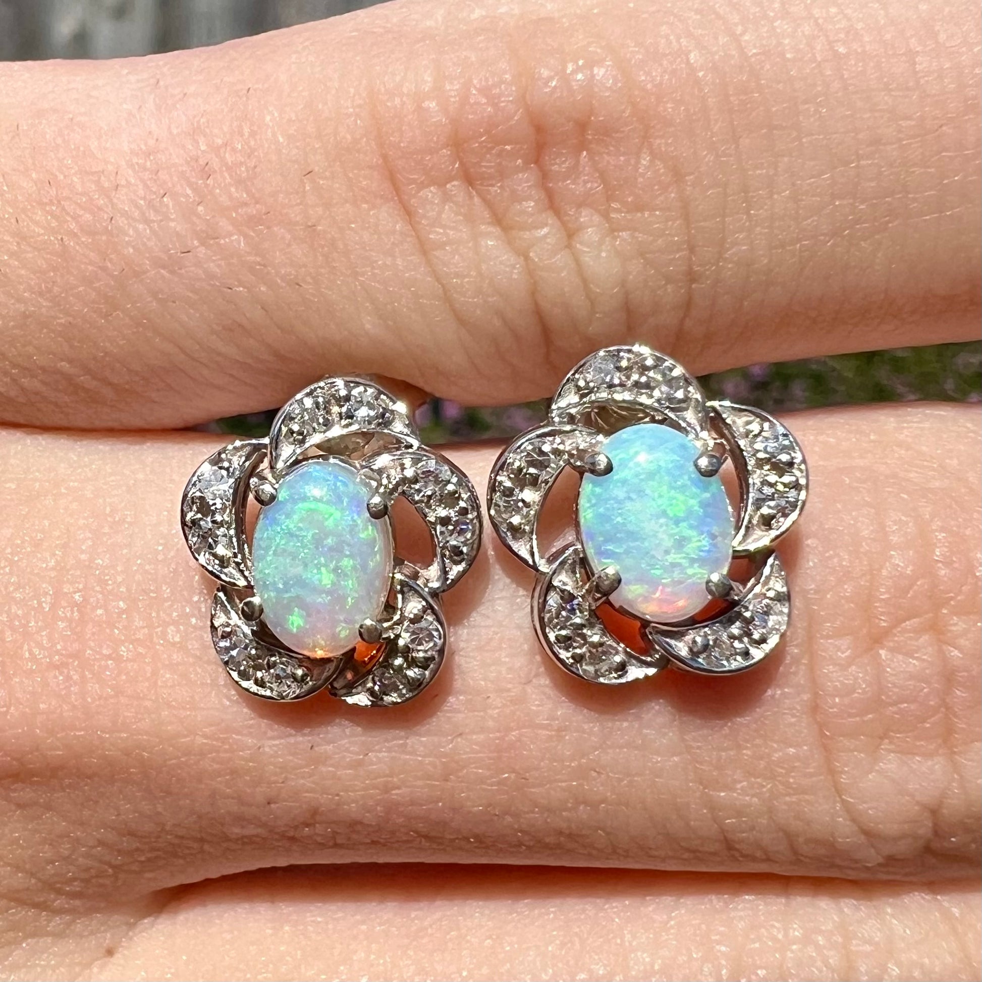 A pair of 14k white gold flower earrings mounted with opals and diamonds.