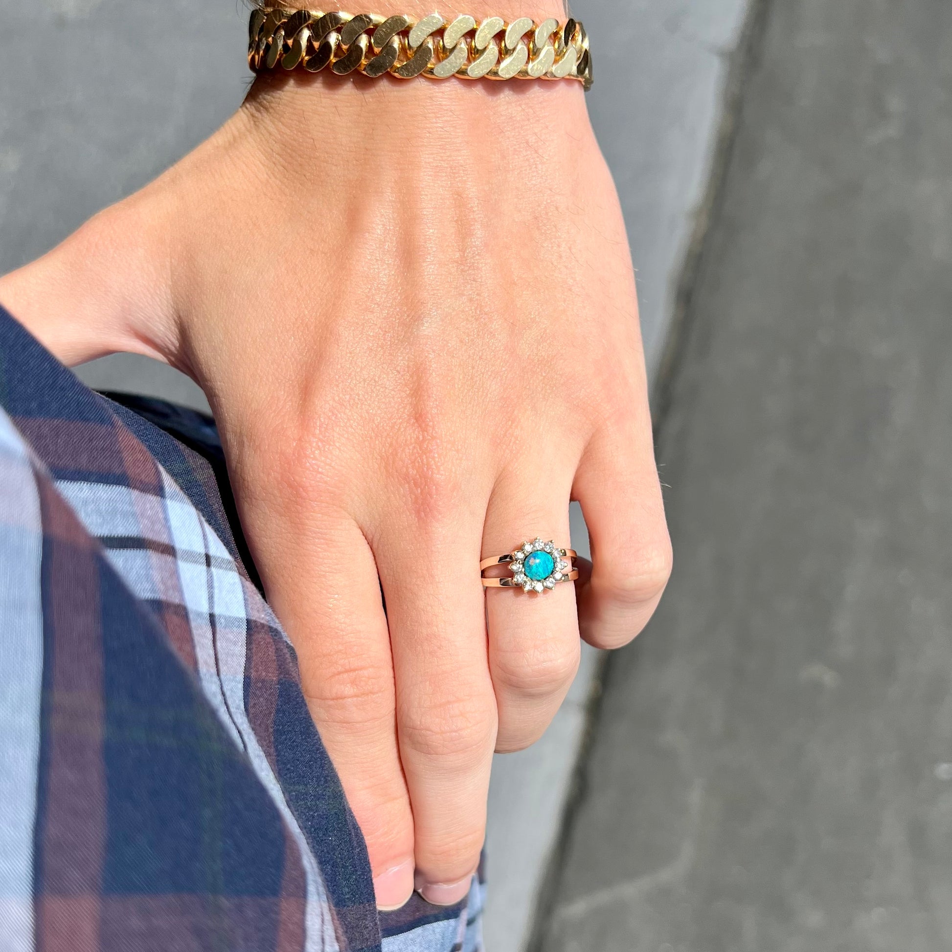 A ladies' round cut black opal and diamond halo ring.  The ring is yellow gold and has a split shank.