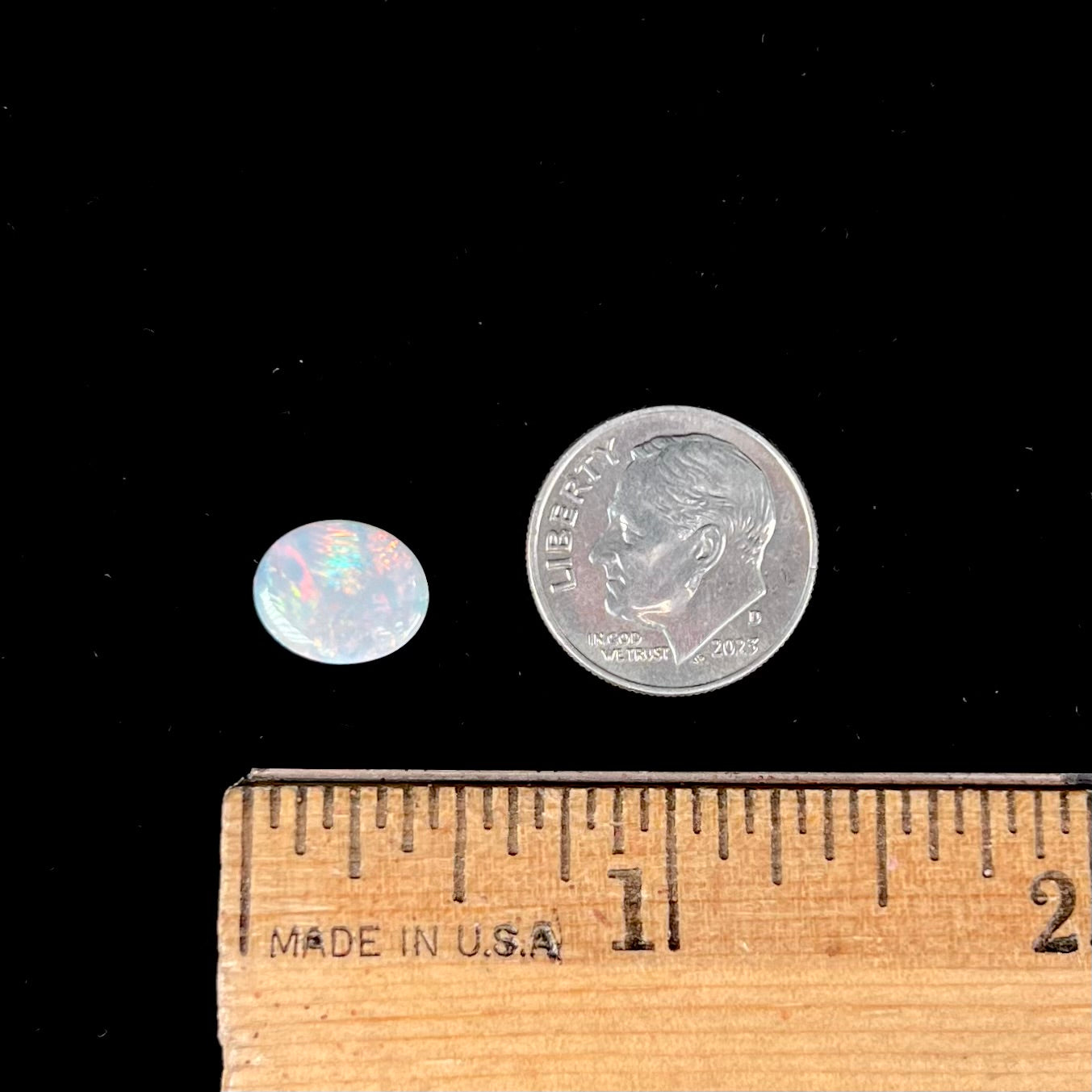 A loose, oval cabochon cut Lightning Ridge light opal stone.