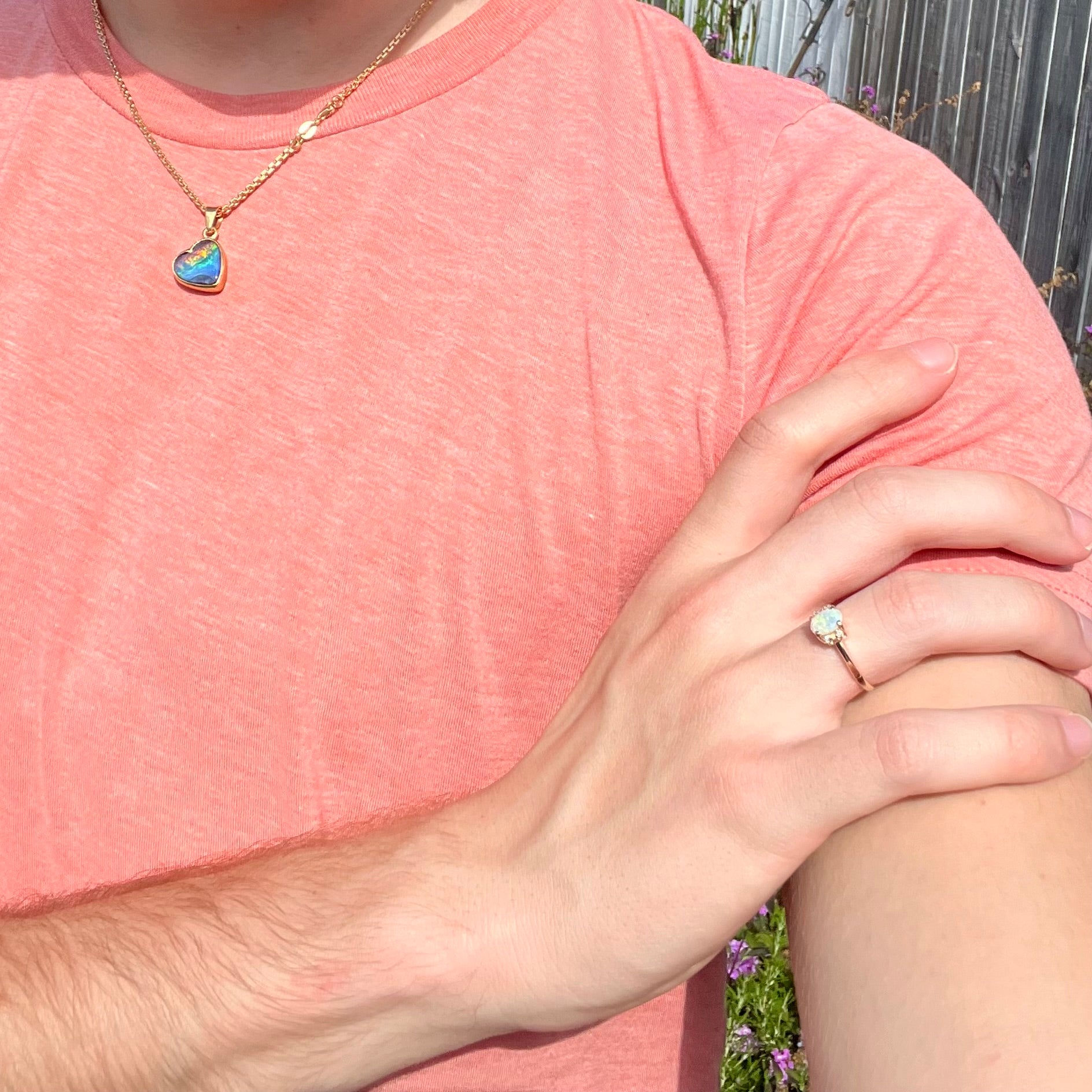 A dainty yellow gold ring set with a Coober Pedy opal with green flashfire pattern and diamond accents.