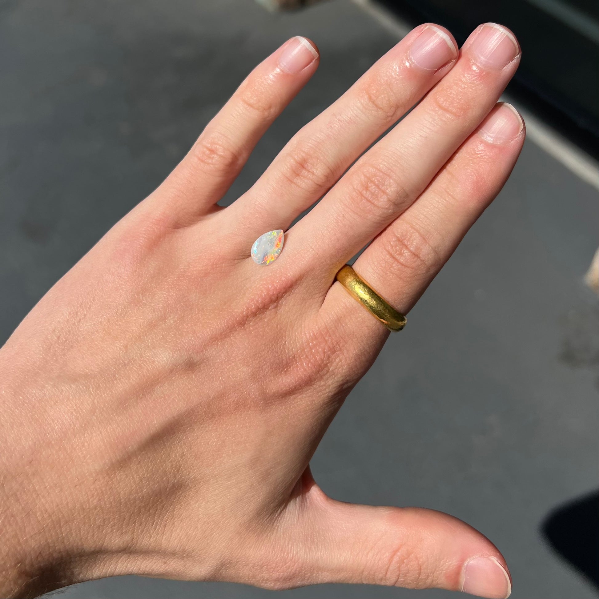 A loose, pear shaped Australian white opal stone.  The stone plays every color of the rainbow.