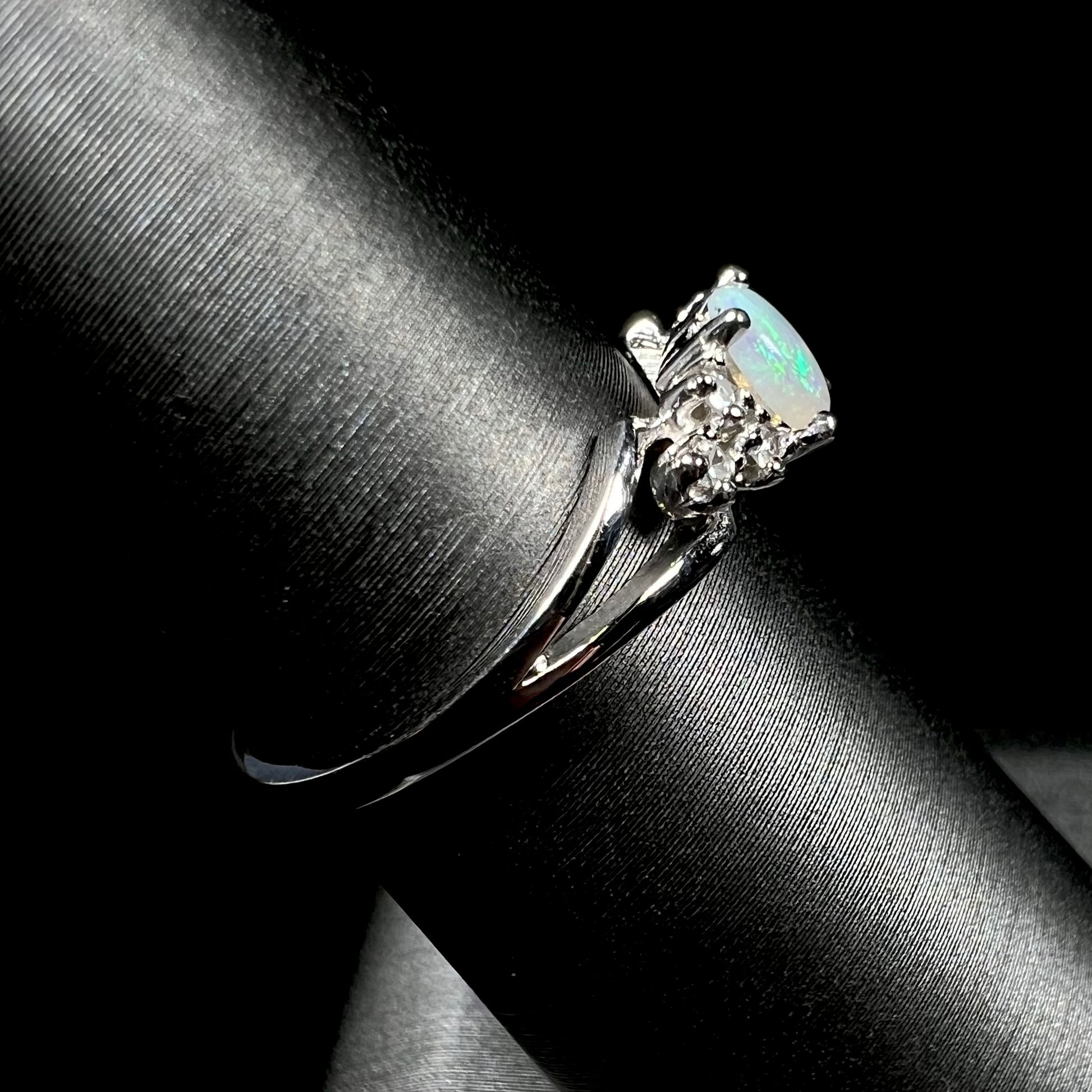 A ladies' white gold opal ring mounted with round diamond accents.