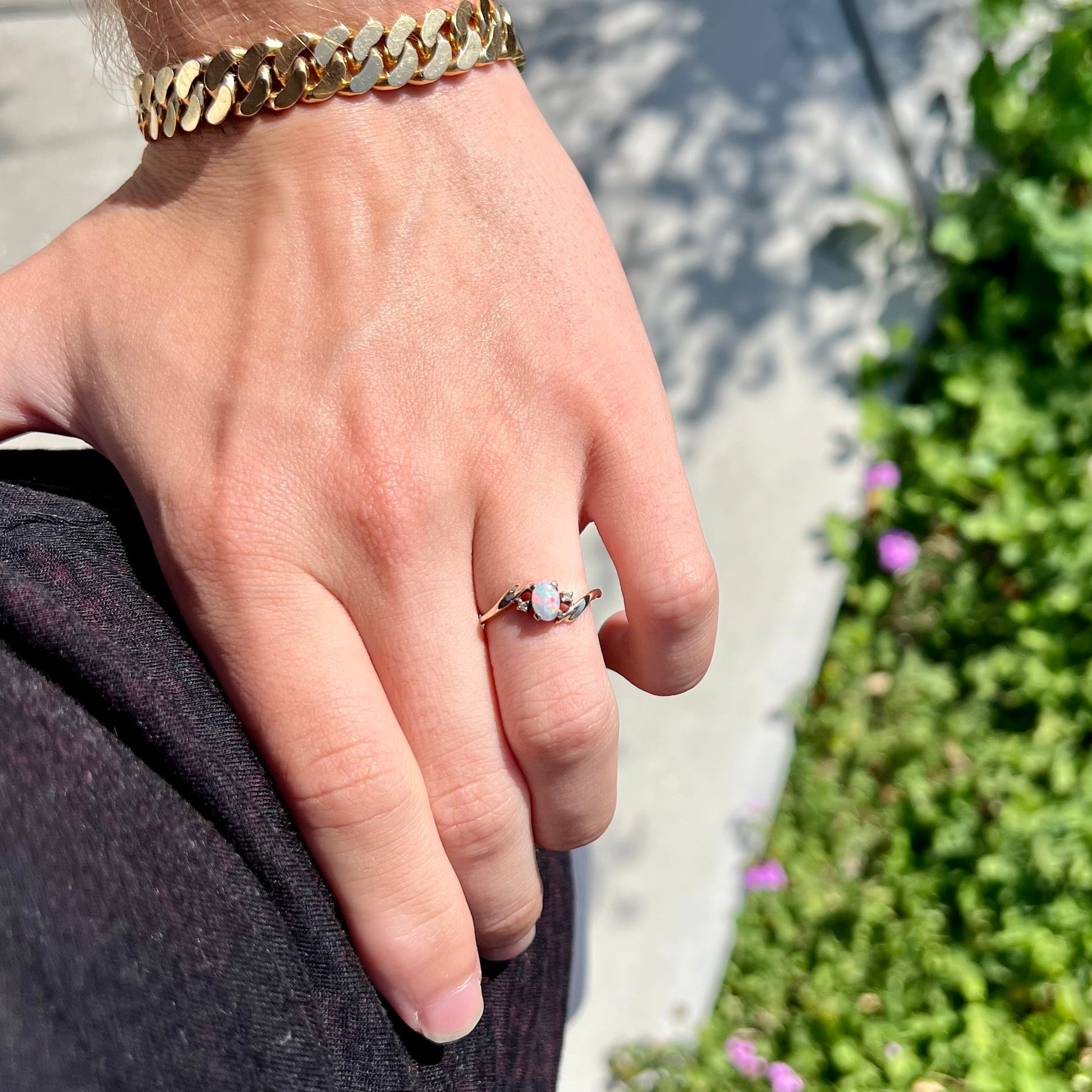 An oval cabochon cut opal and diamond engagement ring in yellow gold.