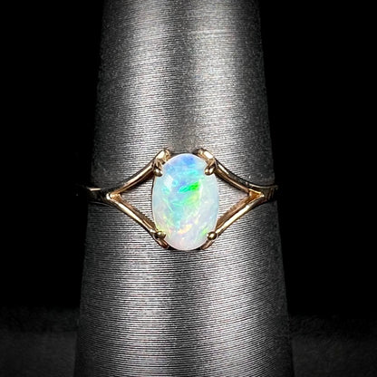 A ladies' simple opal solitaire ring.  The ring is yellow gold with a split shank.