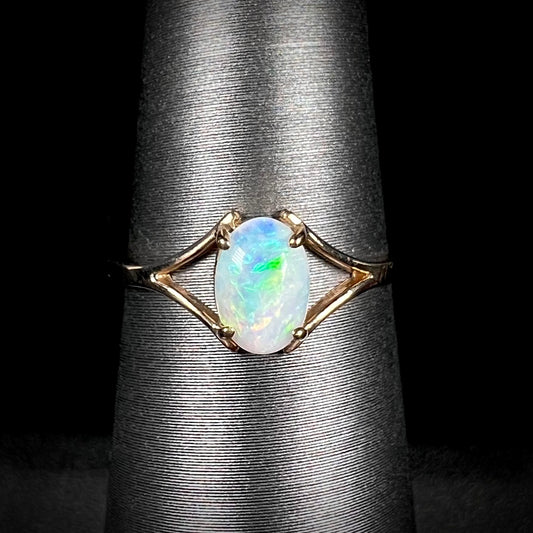 A ladies' simple opal solitaire ring.  The ring is yellow gold with a split shank.