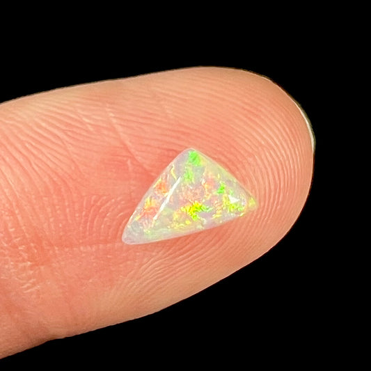 A loose, triangular cut crystal opal from Lightning Ridge, Australia.