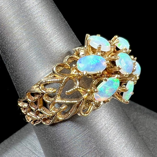 A vintage, 1950's style opal cluster ring cast in yellow gold with a heart shaped filigree design.