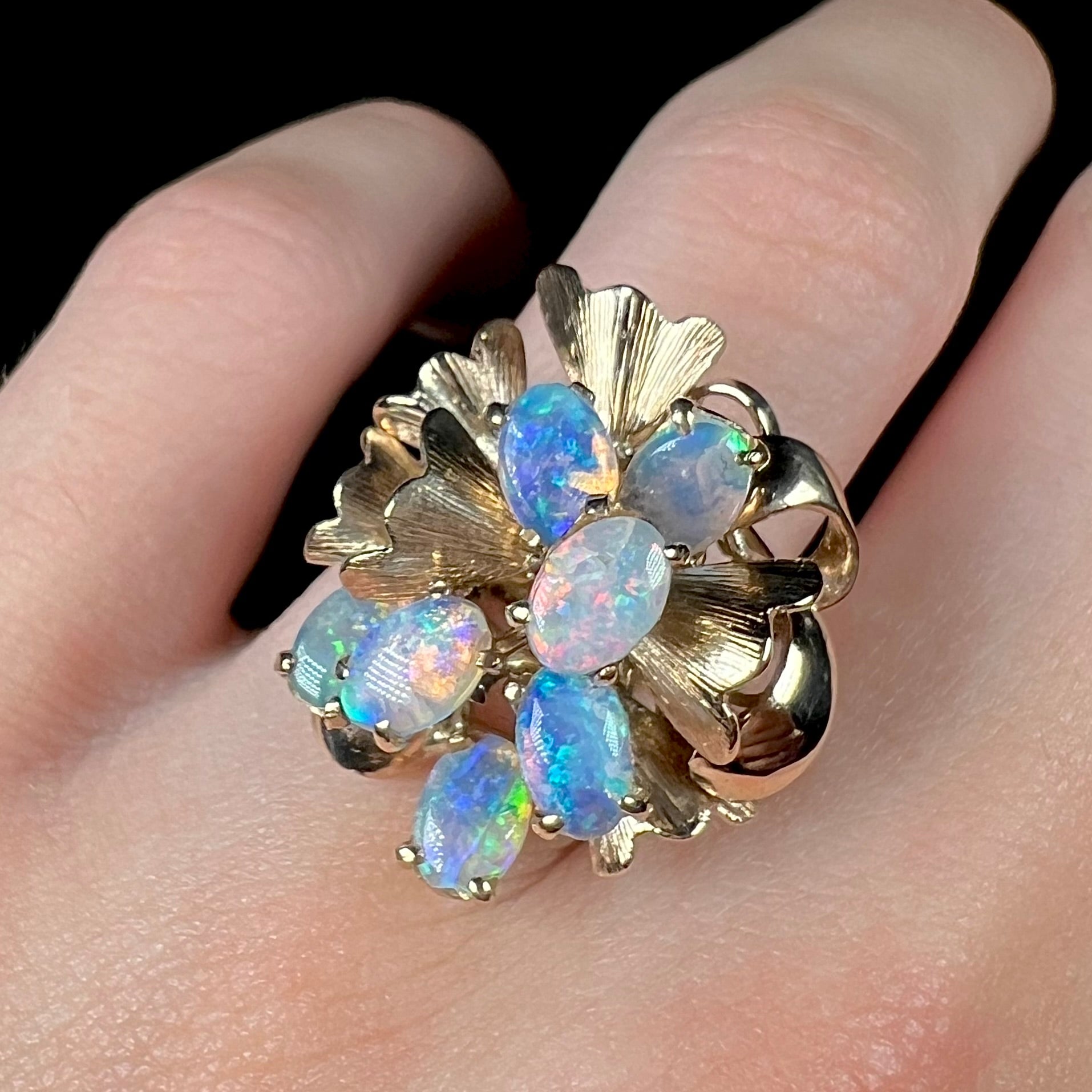 A ladies' vintage, modernist style opal cluster ring in yellow gold.  The ring is tall with a high profile.