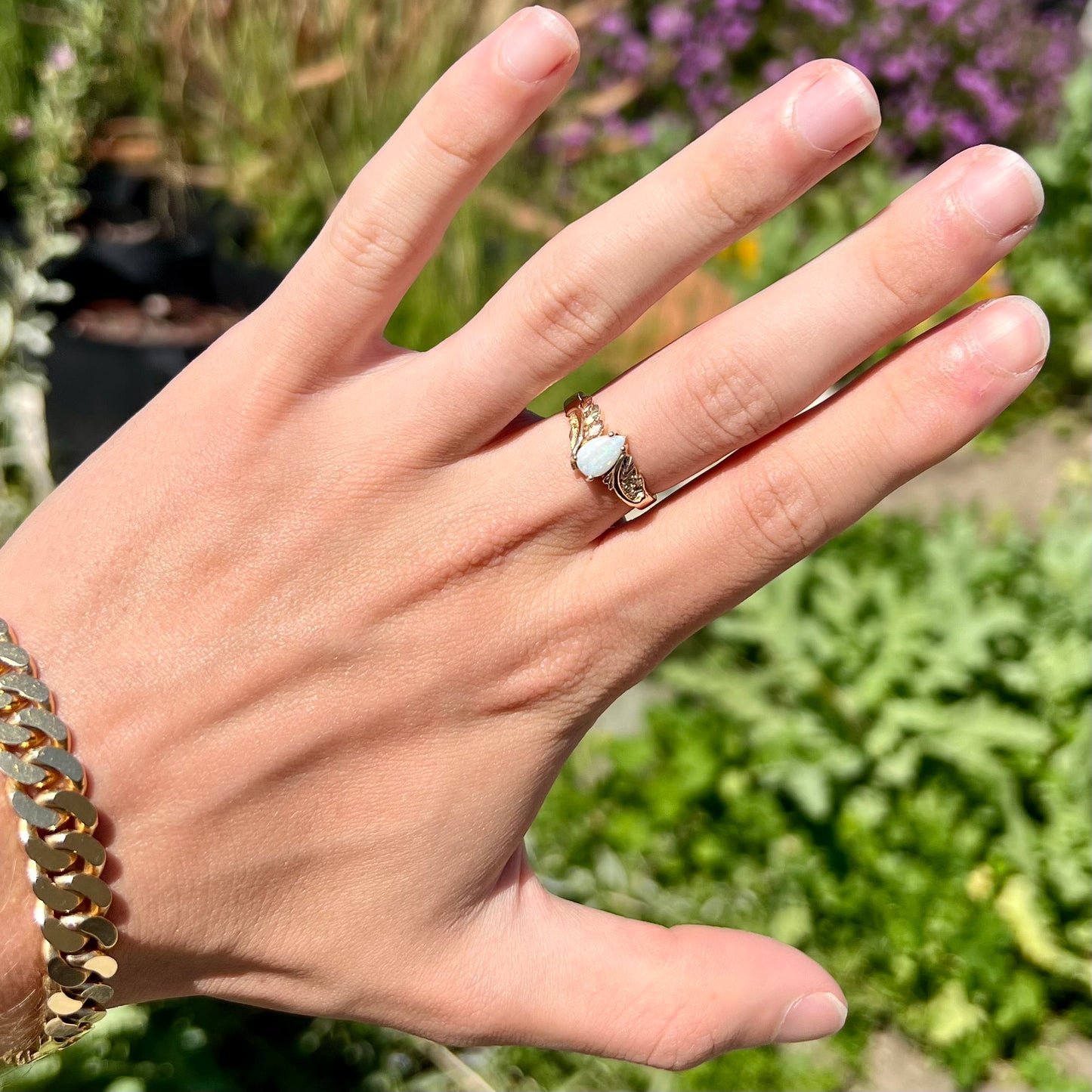 A ladies' two-tone yellow and rose Black Hills gold opal and diamond ring.  The opal is a pear shaped cabochon.