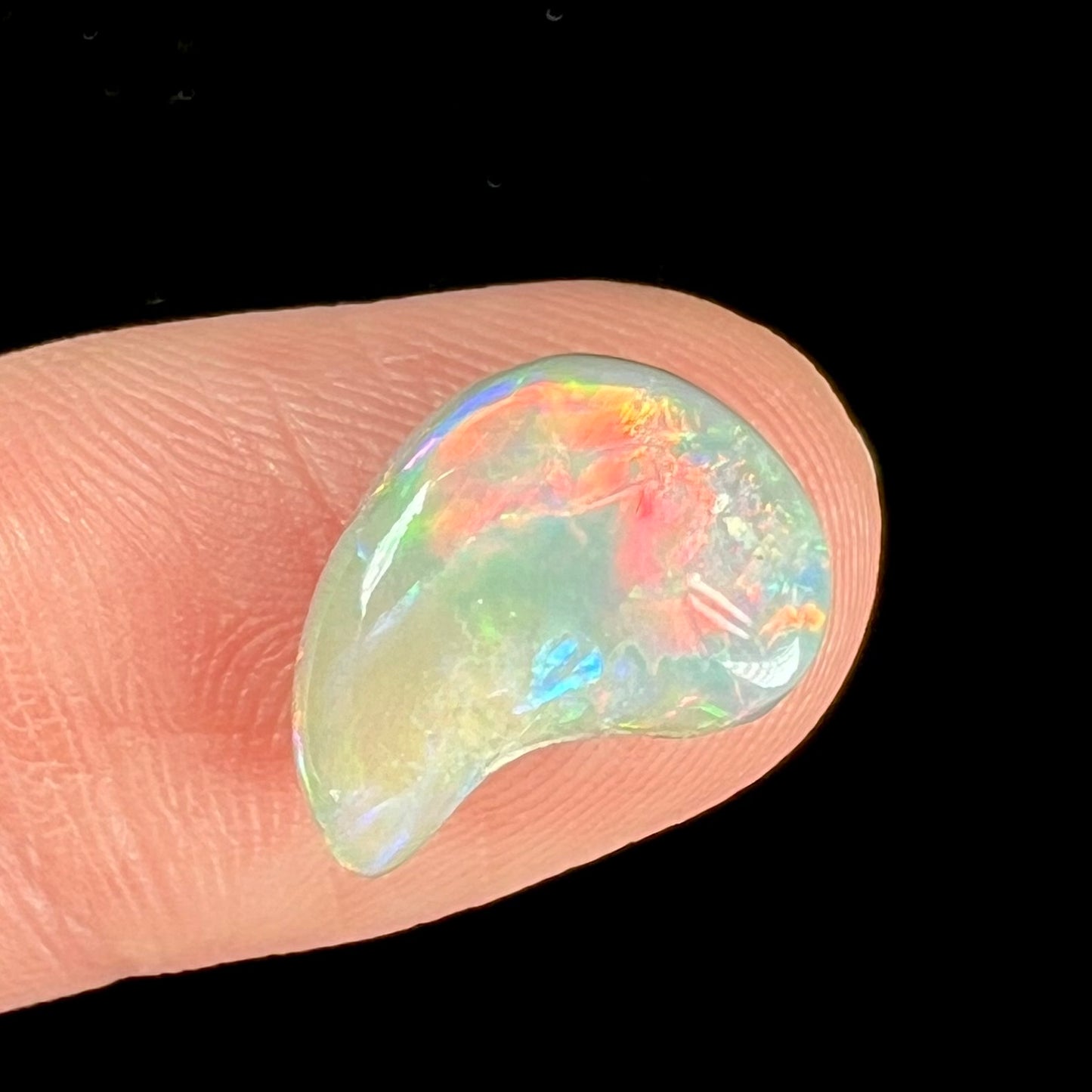 A loose, drop shaped opal stone from Lightning Ridge, Australia.  The stone has bright red fire.