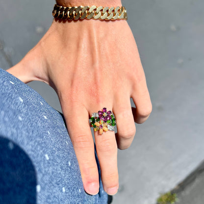 A ladies' gemstone flower design cluster ring set with Ethiopian fire opals, chrome diopsides, rhodolite garnets, and white topaz stones.