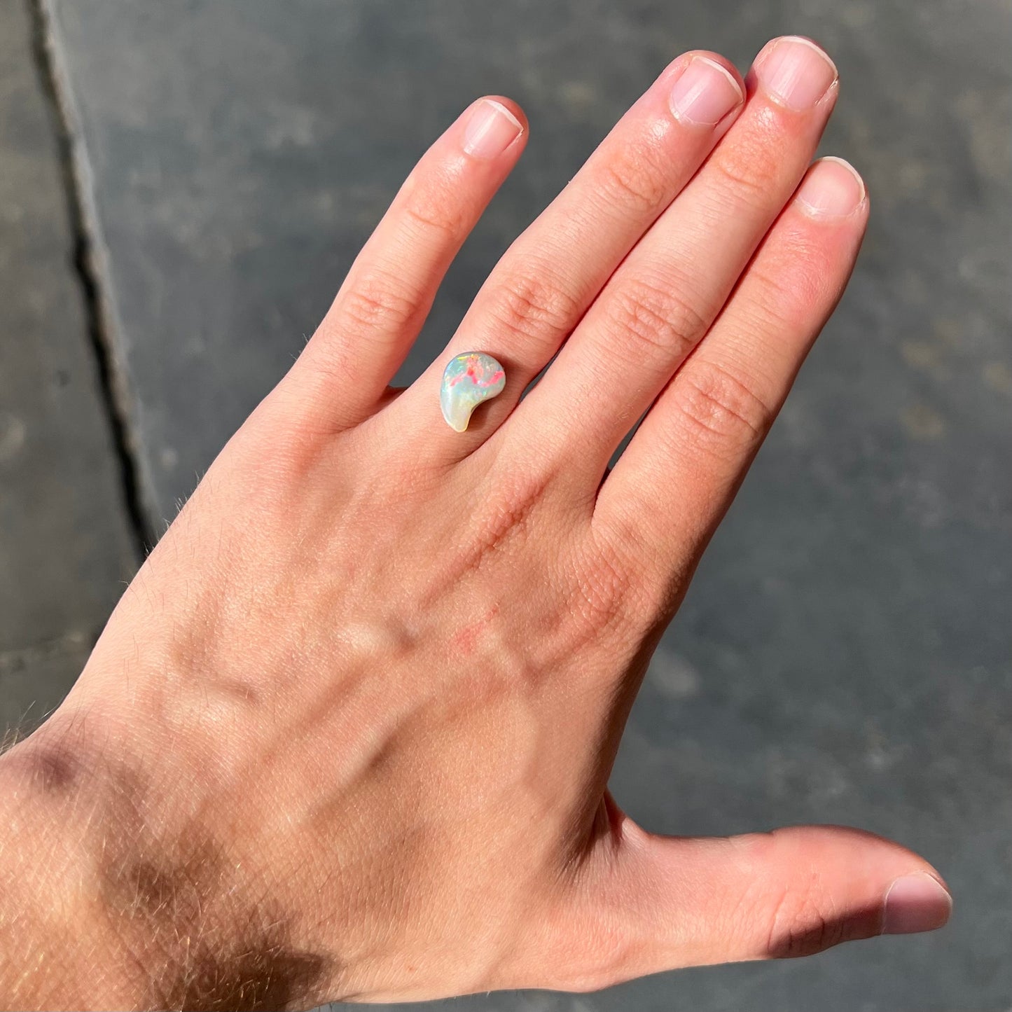 A loose, drop shaped opal stone from Lightning Ridge, Australia.  The stone has bright red fire.