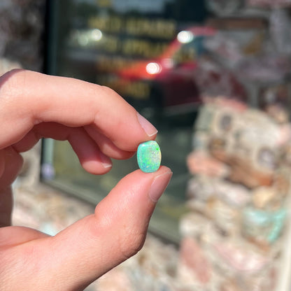 A 2.40ct barrel shaped Lightning Ridge semi-crystal opal.  The stone has blue and green colors.