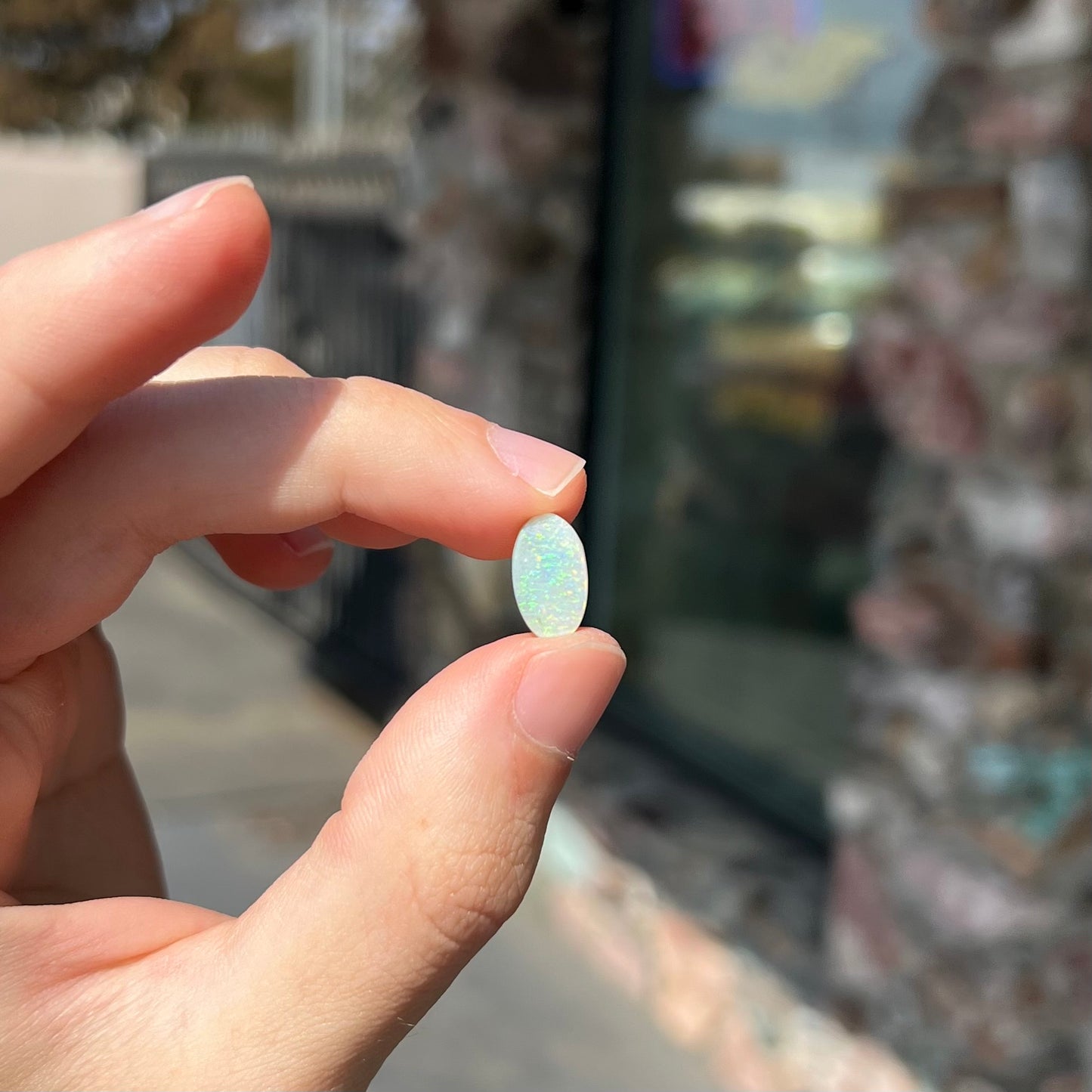 A loose, oval cabochon cut white opal stone from Coober Pedy, Australia.