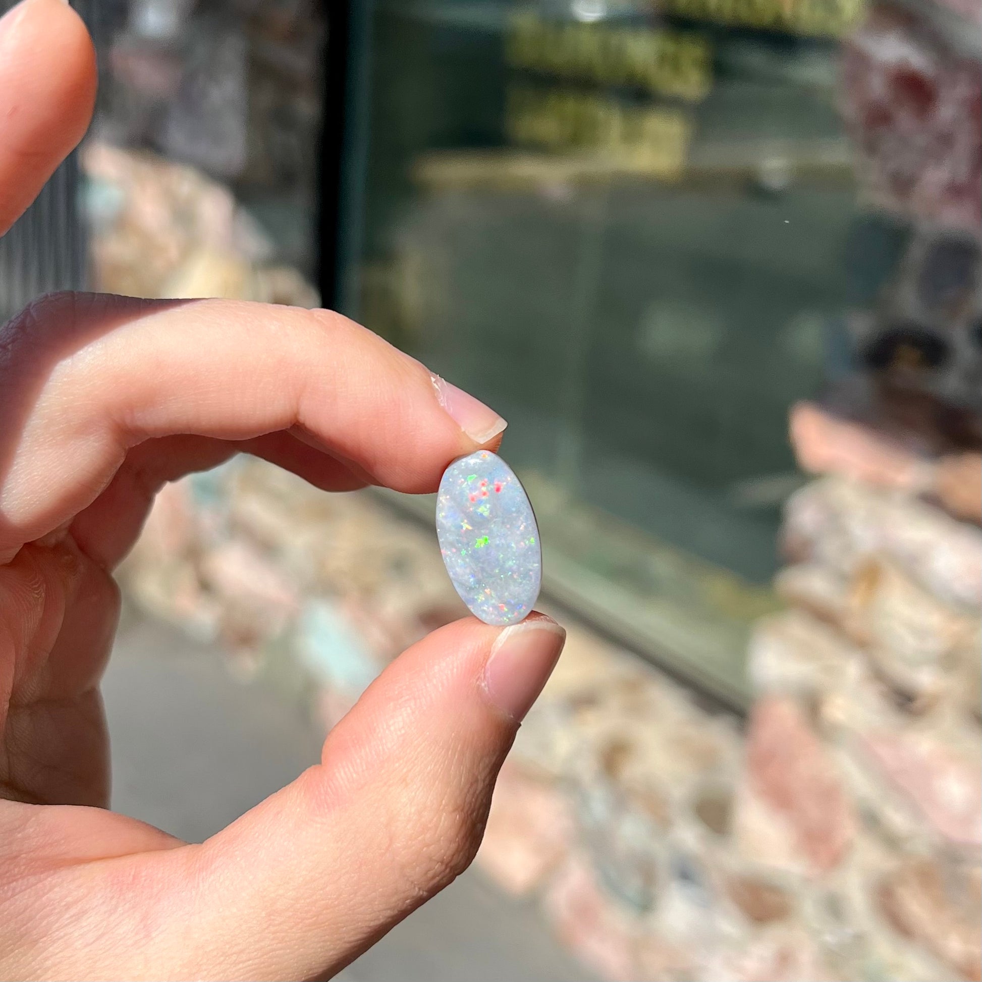 A loose, oval cut semi-black opal stone from Lightning Ridge, Australia.