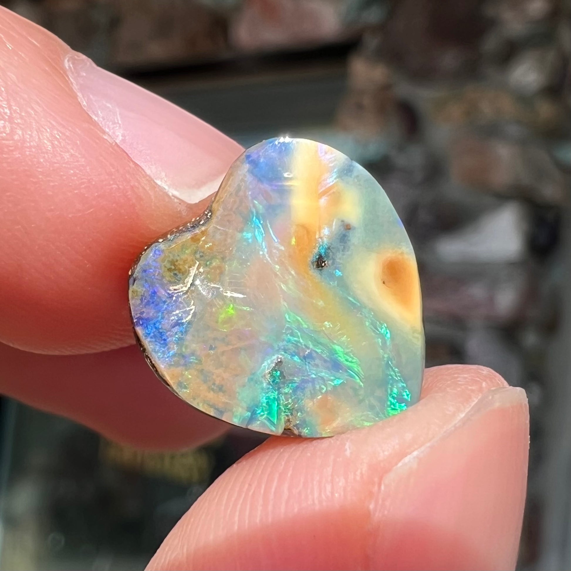 A loose, 5.90 carat heart shaped boulder opal stone from Quilpie, Australia.  The opal has blue flashes.