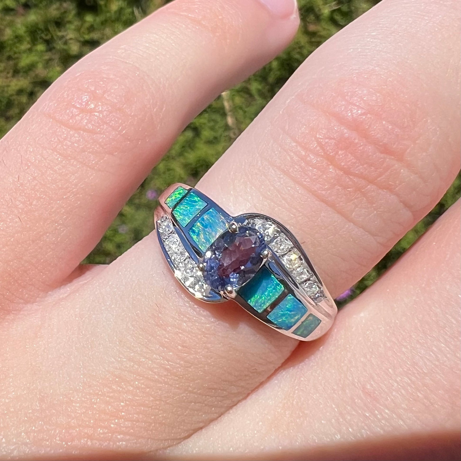 A ladies' white gold tanzanite ring with black opal doublet and diamond accents.