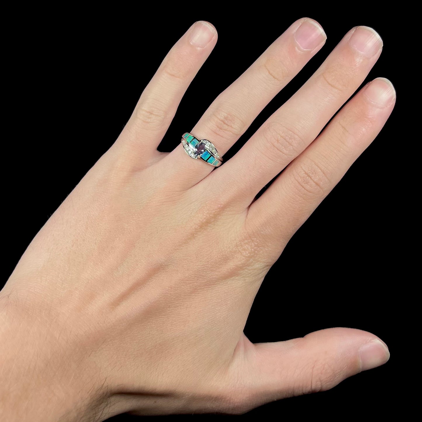 A ladies' white gold tanzanite ring with black opal doublet and diamond accents.