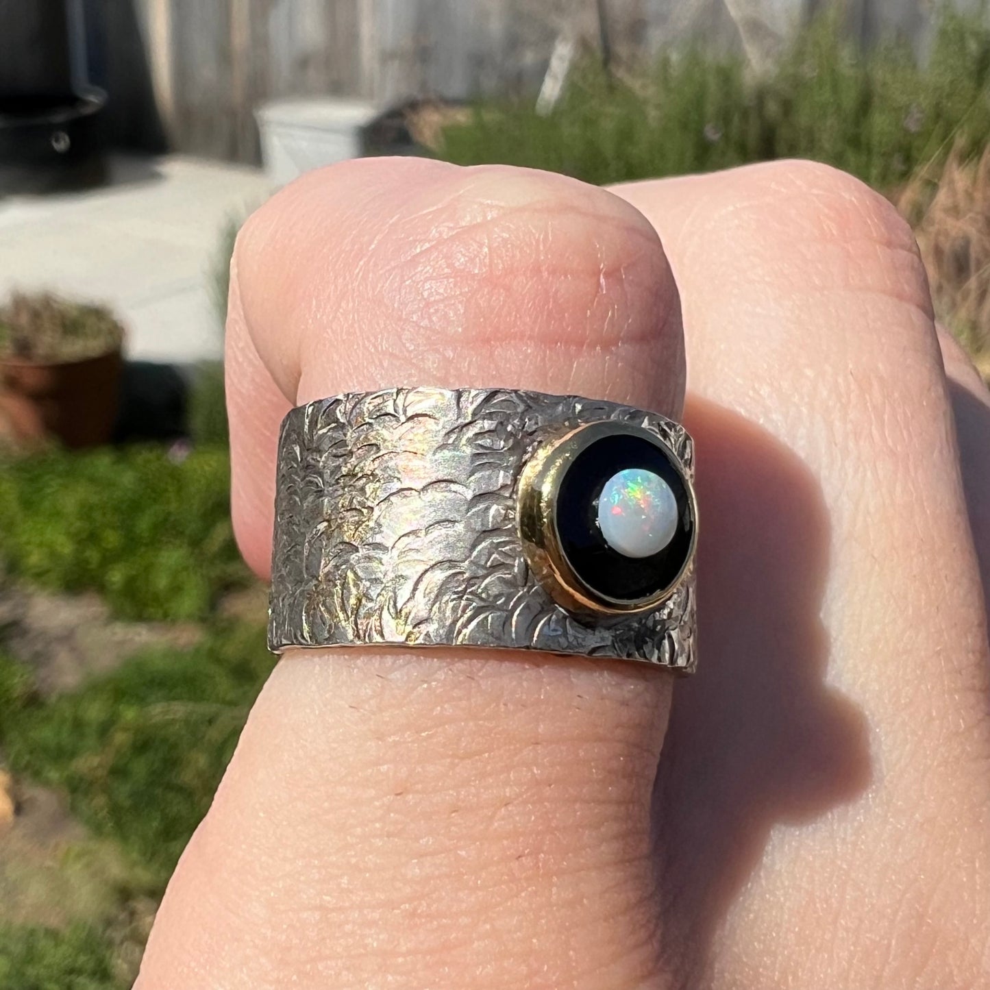 An opal and black onyx inlay ring in a sterling silver cigar-style pinkie ring.