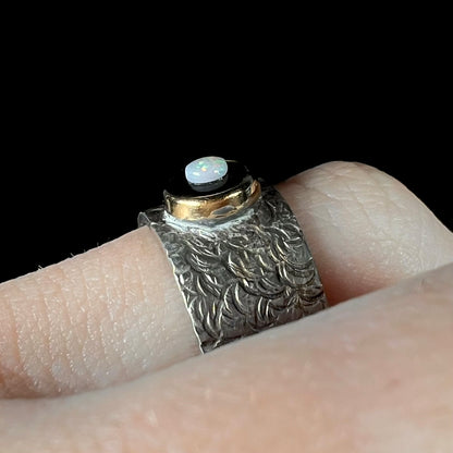 An opal and black onyx inlay ring in a sterling silver cigar-style pinkie ring.