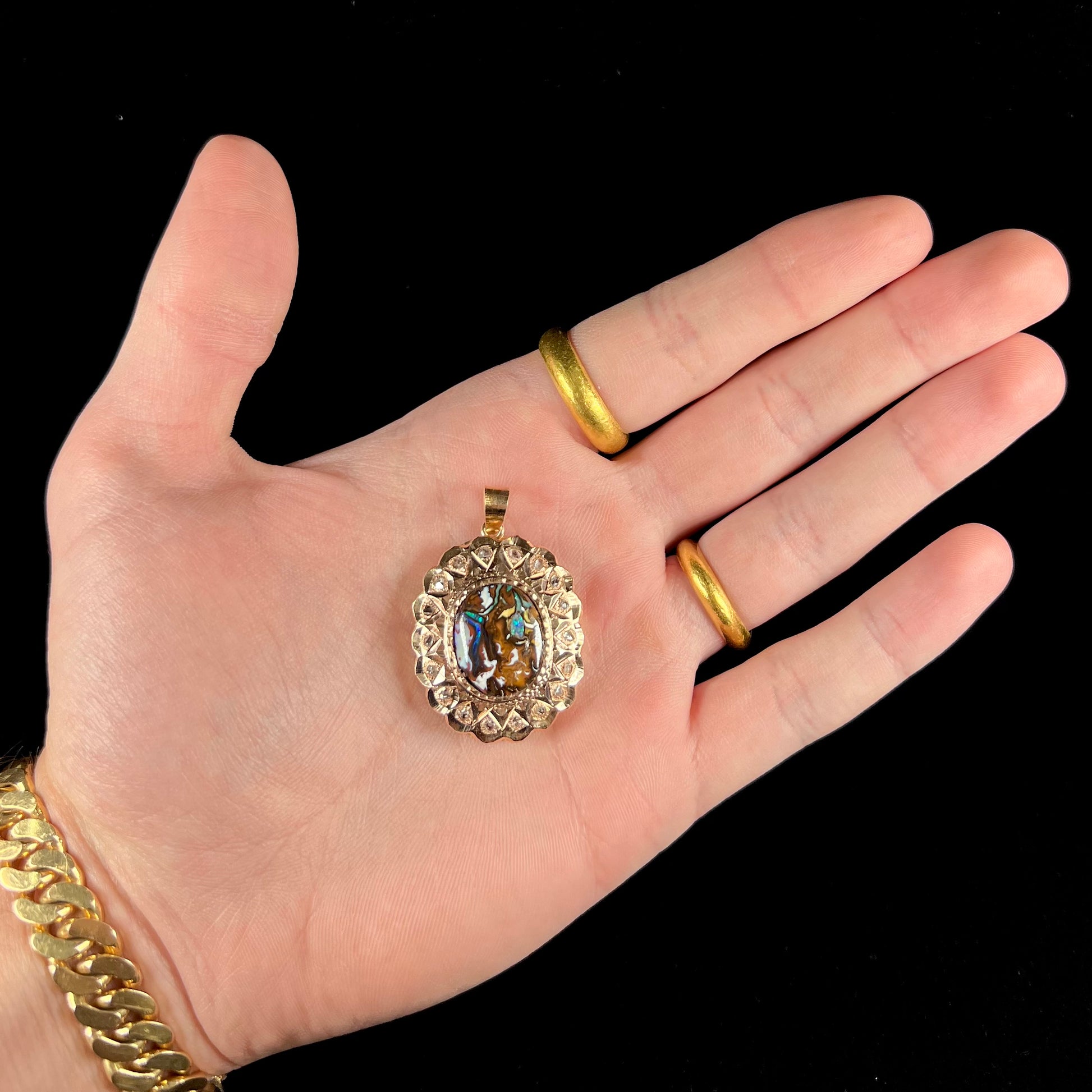 An antique 18 karat yellow gold pendant set with rough diamonds and an oval cut boulder opal from Koroit, Australia.